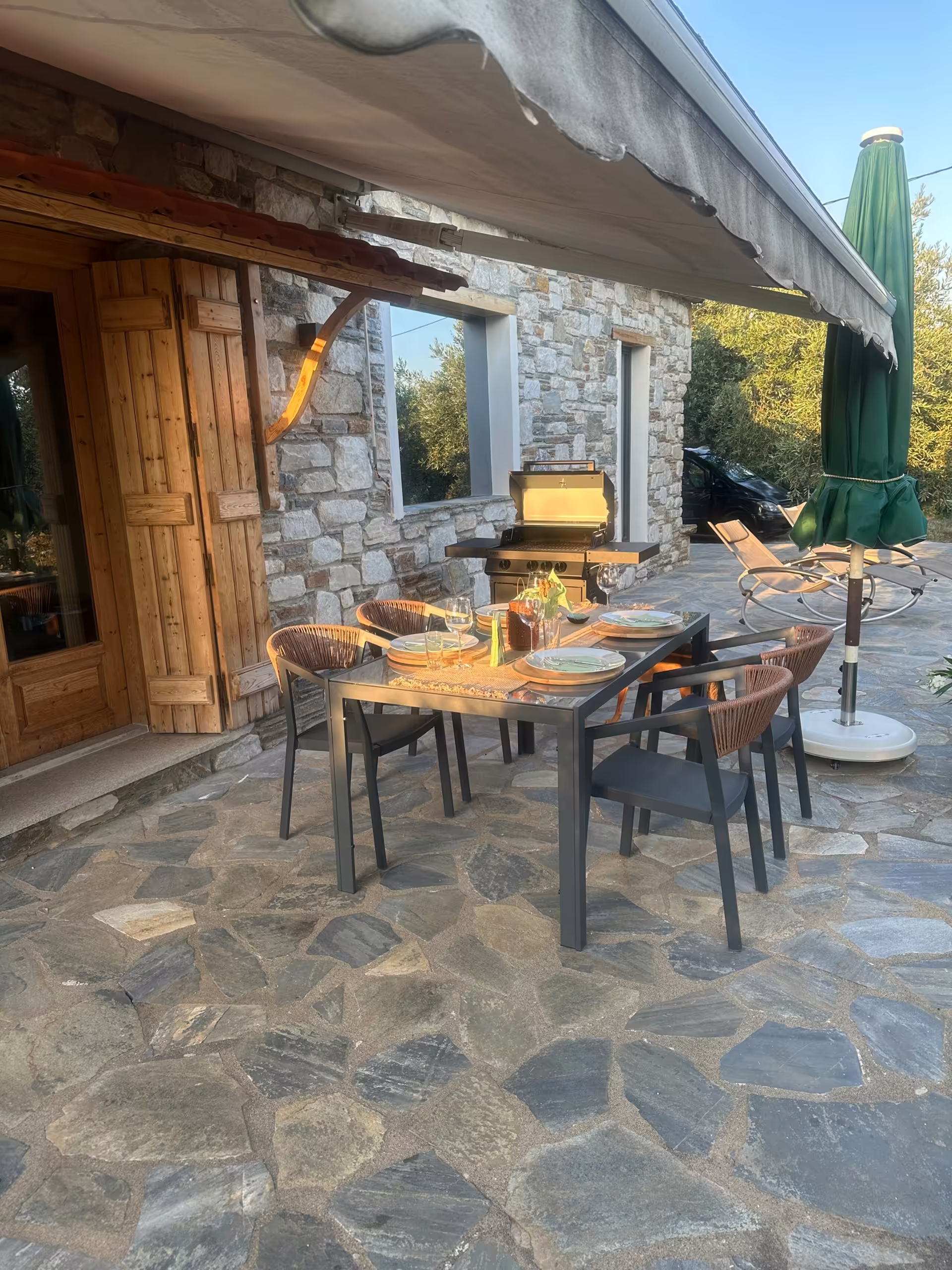 &Uuml;berdachte Terrasse mit langem Esstisch und Blick aufs Meer