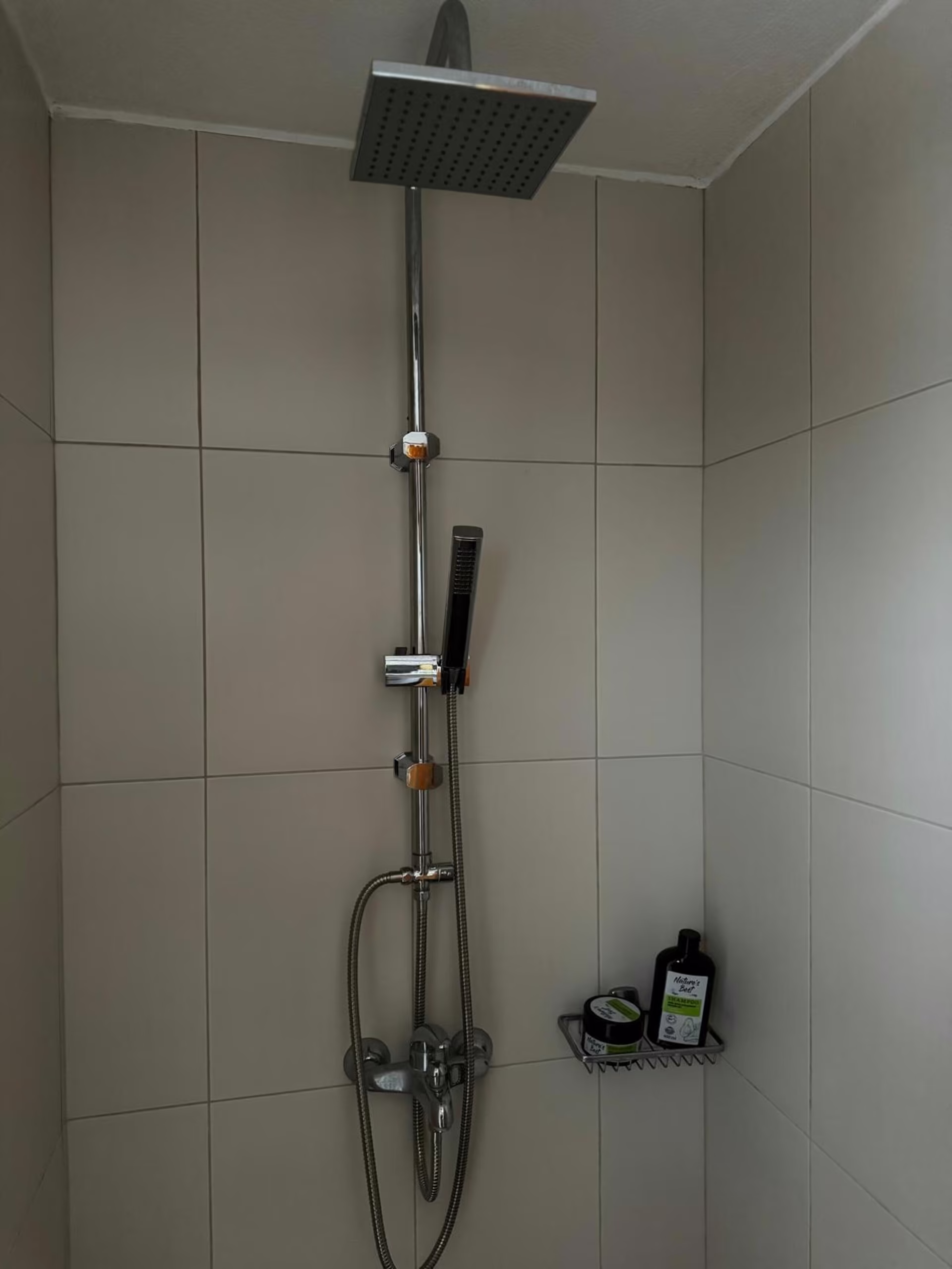 Regendusche im gefliesten Duschbereich