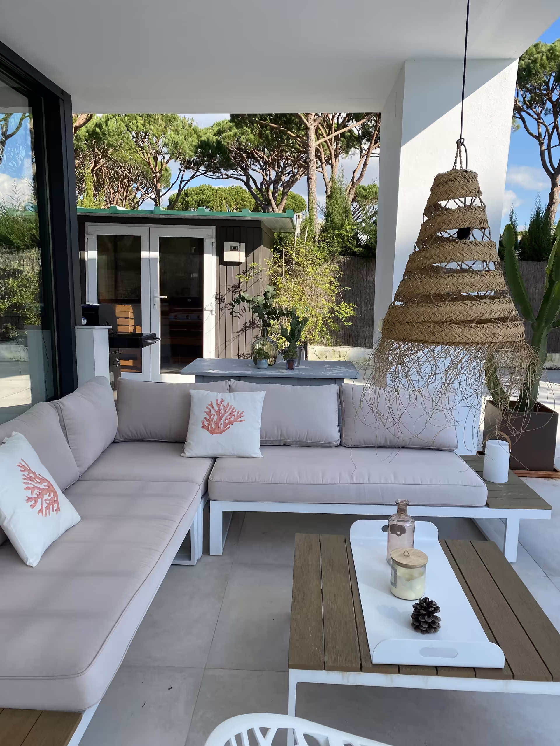&Uuml;berdachte Terrasse mit Loungesofa und Korbleuchten