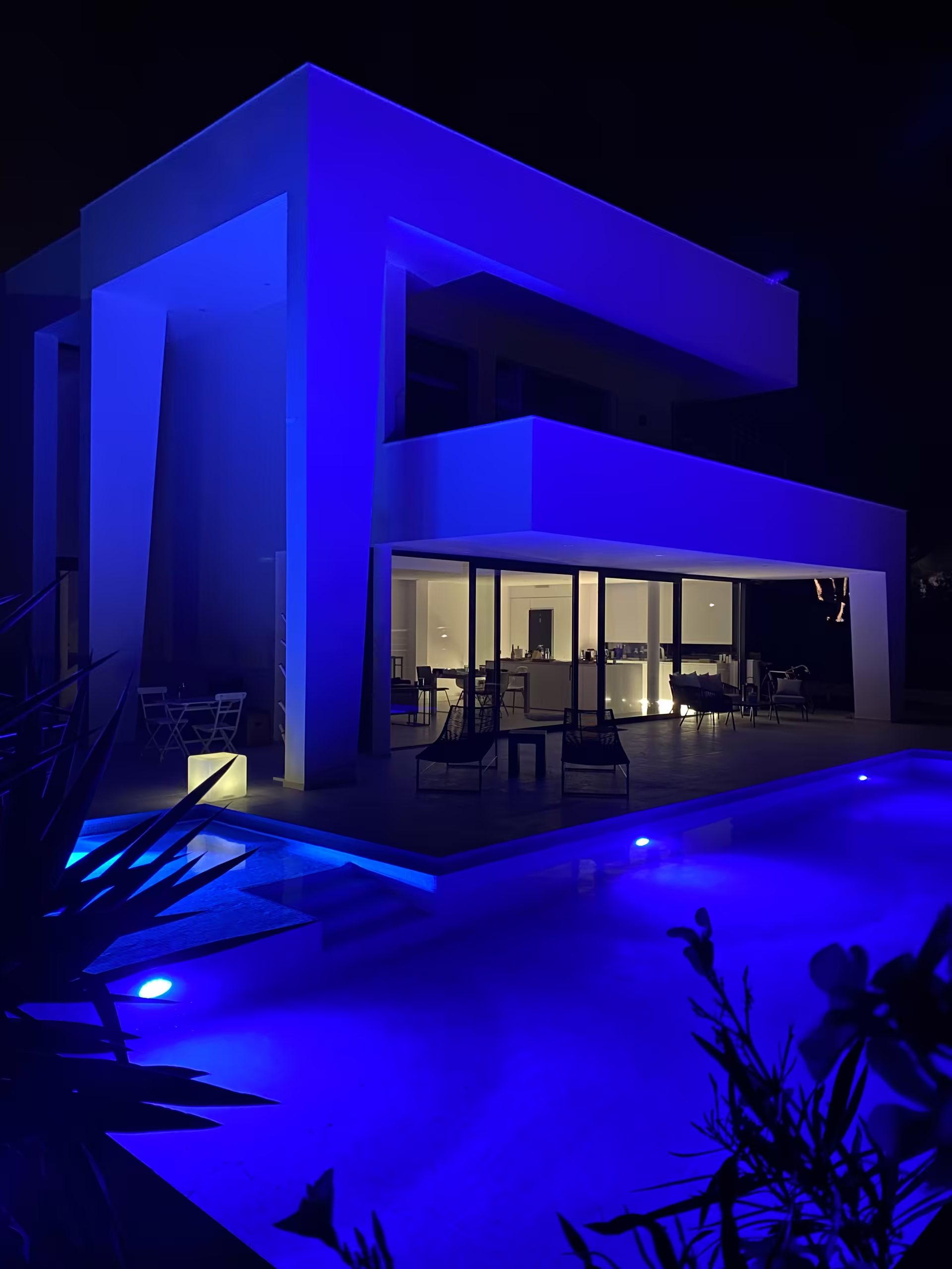 Die Villa bei Nacht, Pool und Fassade blau beleuchtet