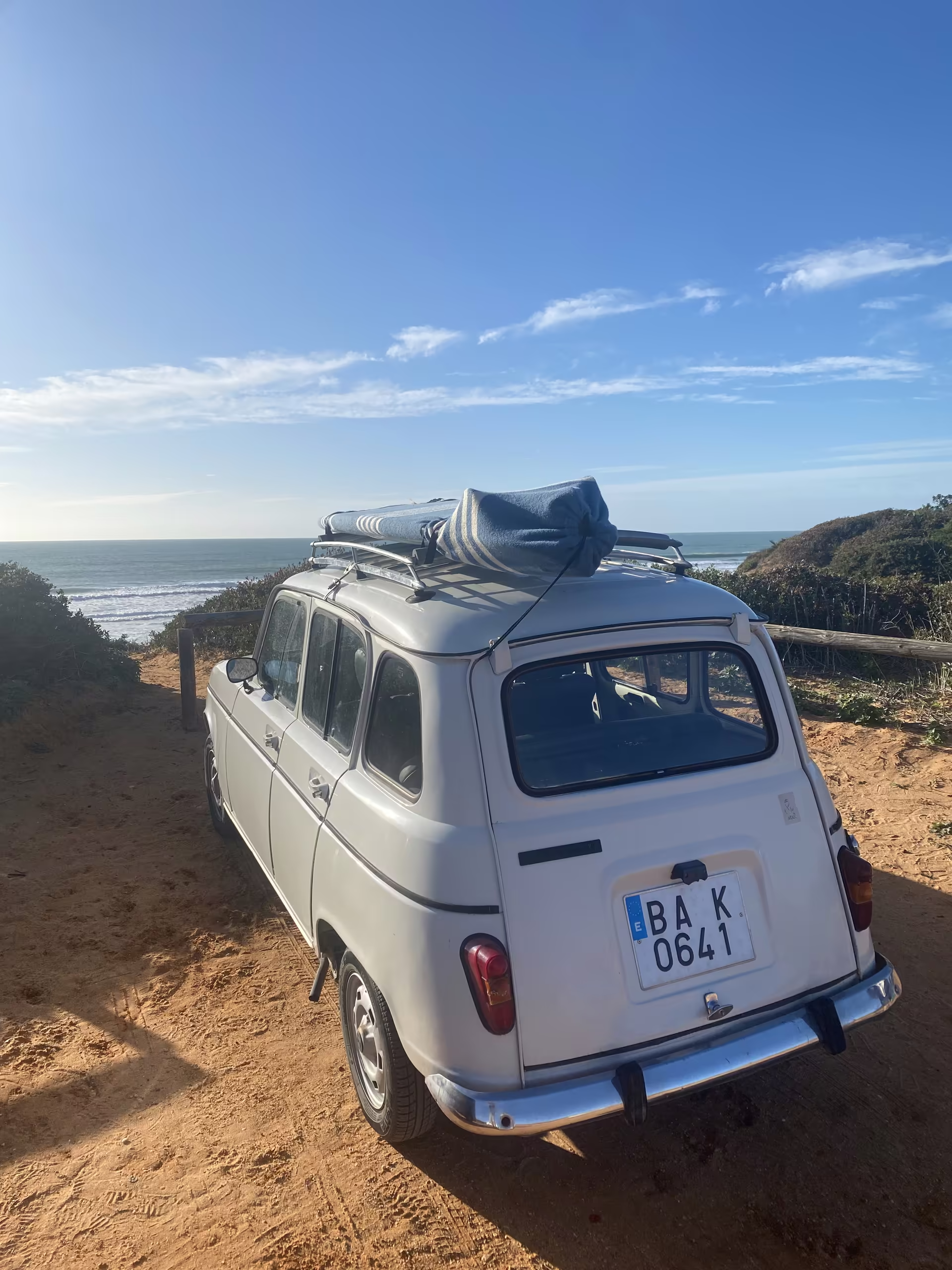 Alter Renault mit Dachgep&auml;ck am Strand &uuml;ber dem Atlantik