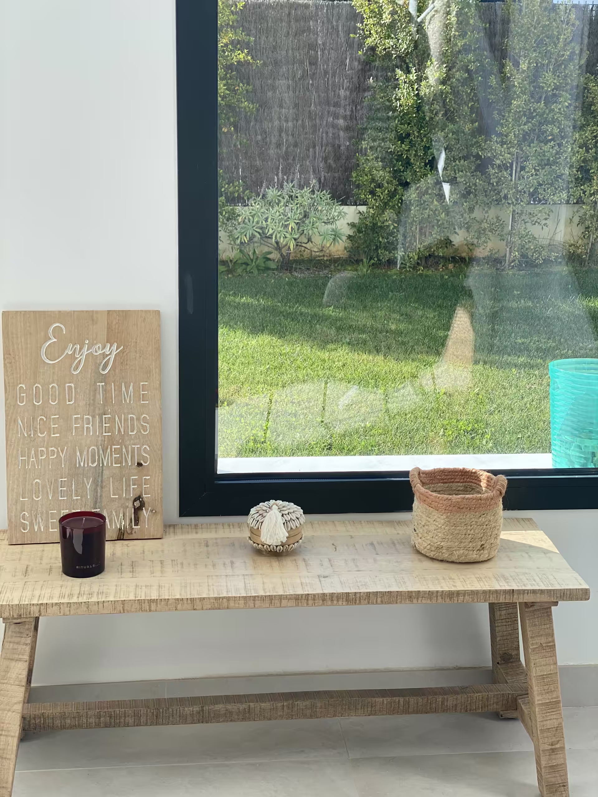 Holzbank im Eingang vor dem bodentiefen Fenster zum Garten