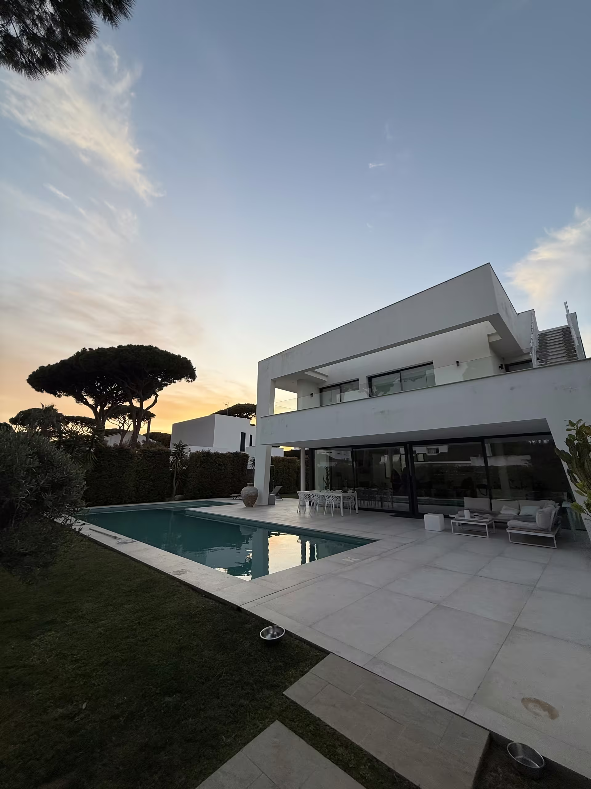 Die Villa im Abendlicht, Blick &uuml;ber den Rasen auf Pool und Terrasse