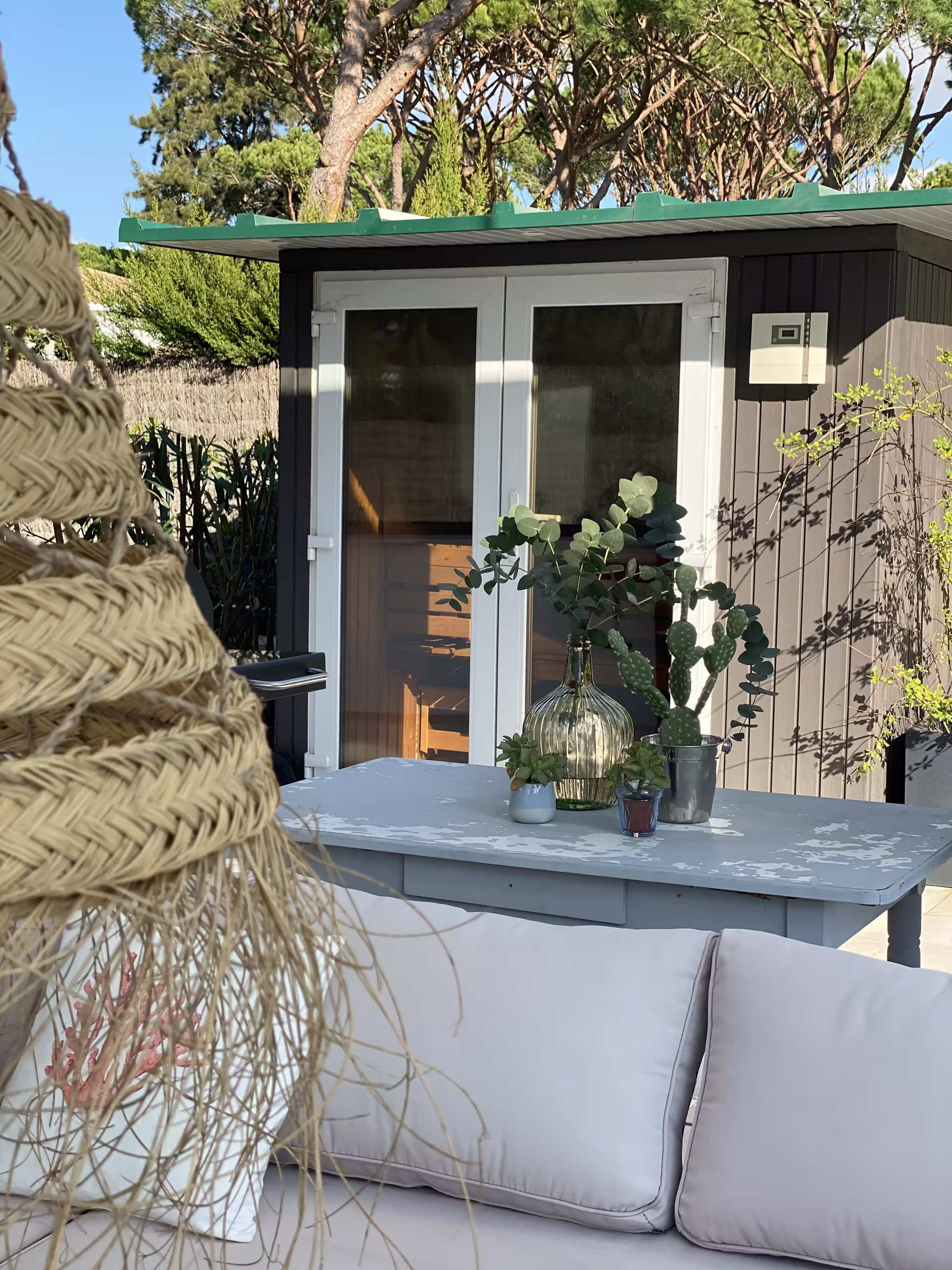Saunahaus im Garten, davor die Sitzecke der Terrasse