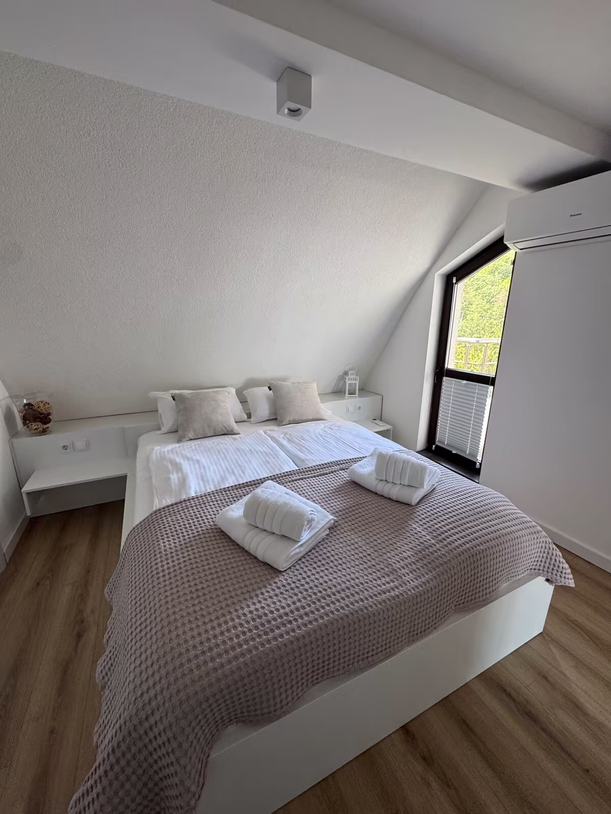 Doppelbett mit Fenster im ersten Schlafzimmer